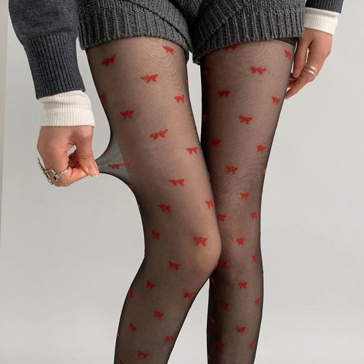 Person wearing black tights with red bows and knitted shorts