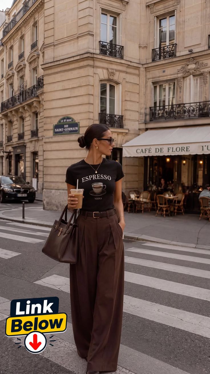 Woman in a black t-shirt and brown pants walking on a city street