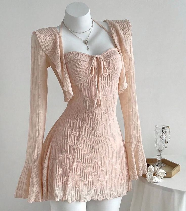Pink dress and matching cardigan on a mannequin with jewelry