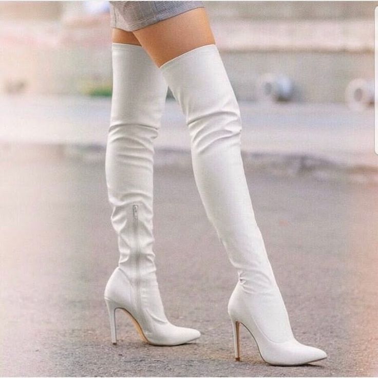Person wearing white thigh-high boots and a short skirt