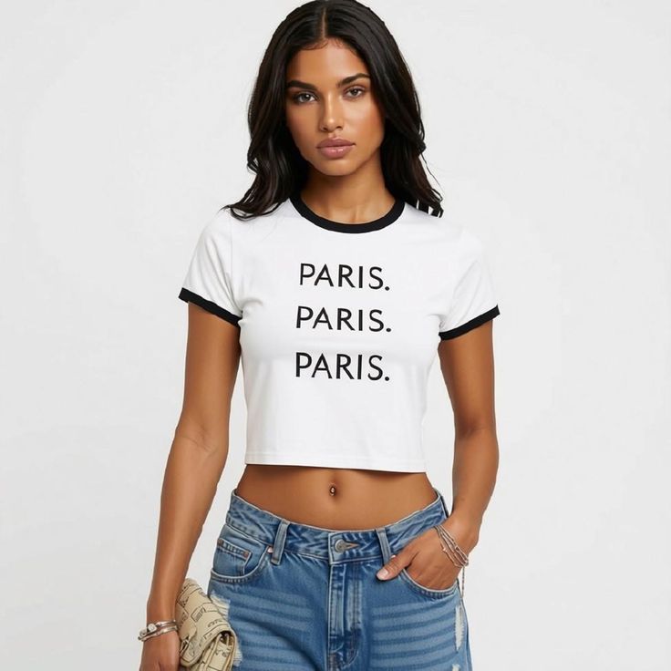 Woman in a white crop top and denim shorts with a belly button piercing