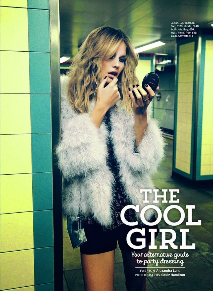 Woman with blonde hair and a fur coat holding a compact mirror indoors