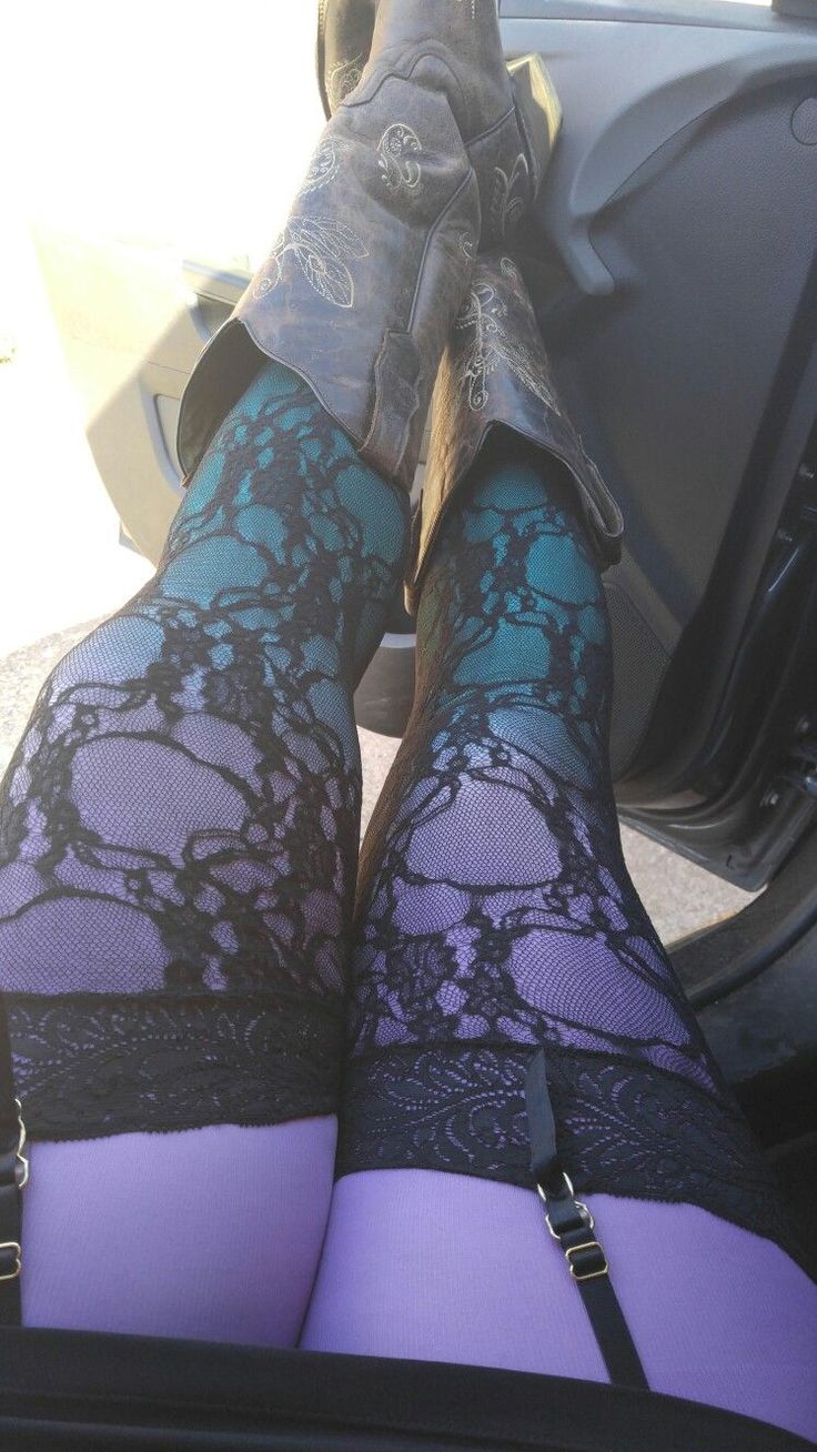 Person wearing cowboy boots, lace stockings, and a garter belt in a car