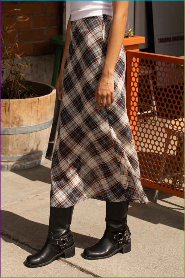 Person wearing a plaid skirt and black boots outdoors