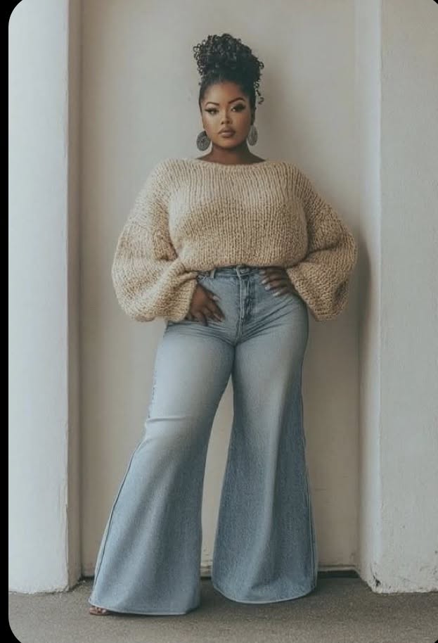 Woman with a high bun and bell bottom jeans posing indoors