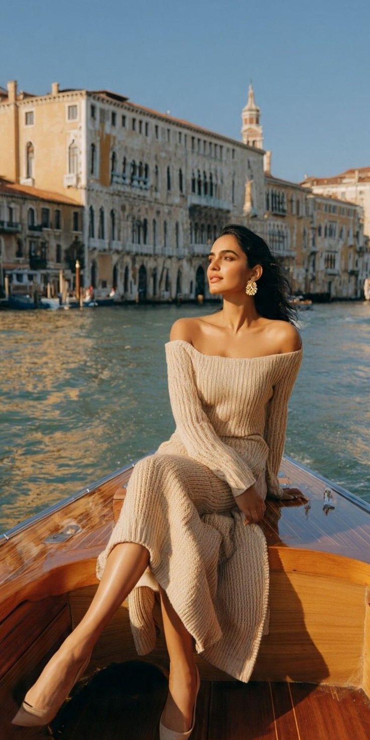Woman in an off-shoulder dress on a boat in a canal at golden hour