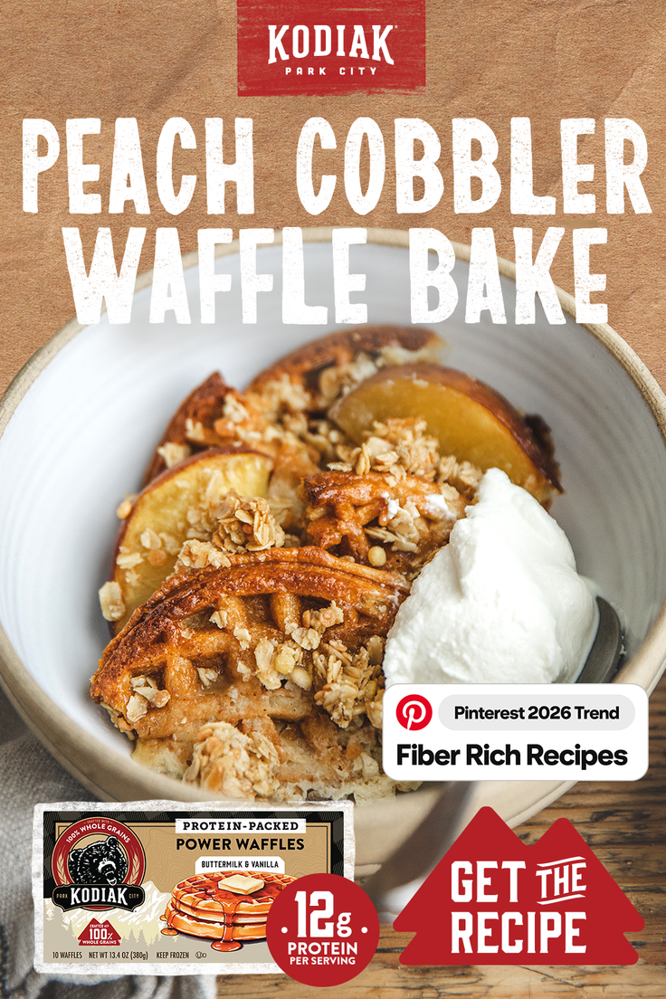 Peach cobbler waffle bake with whipped cream and oat topping in a bowl