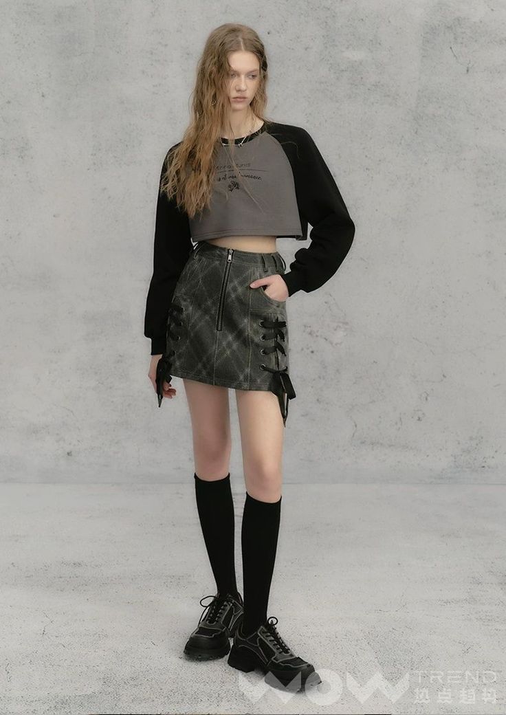 Woman with long hair wearing a crop top and mini skirt with knee-high socks