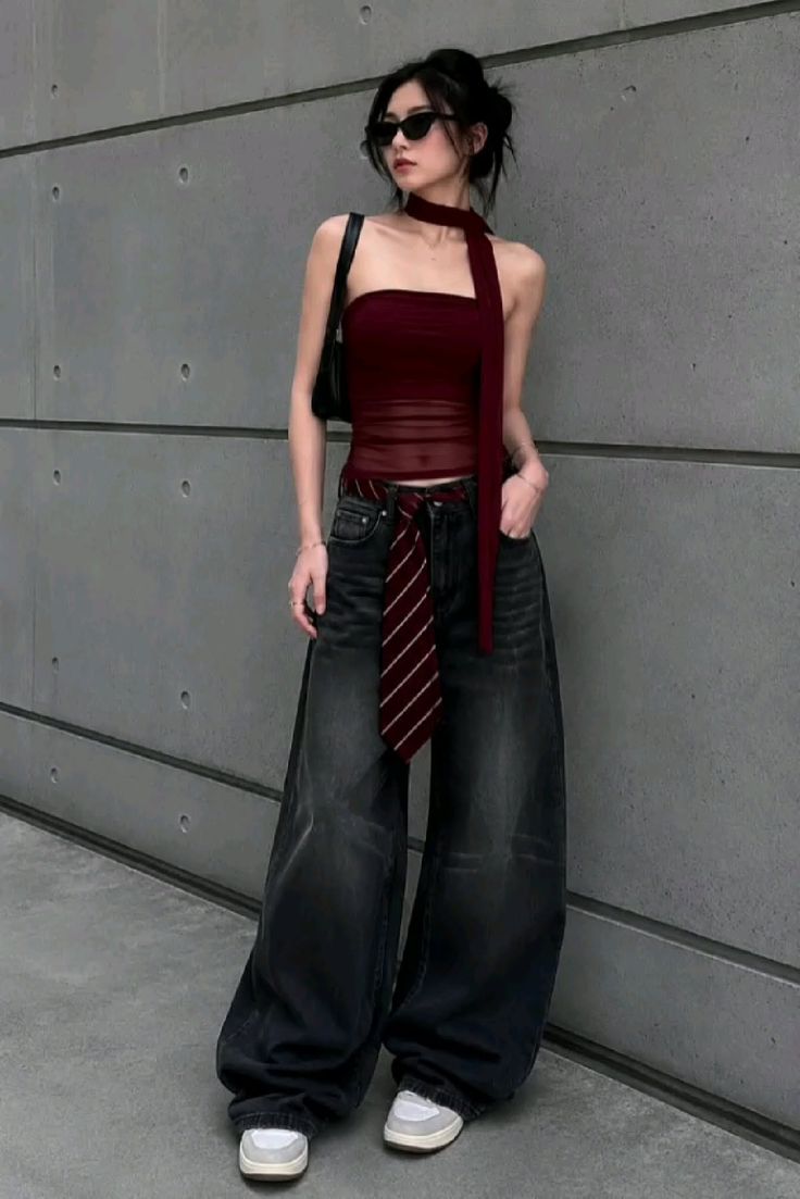 Woman in a strapless top and wide leg jeans with a tie as a belt