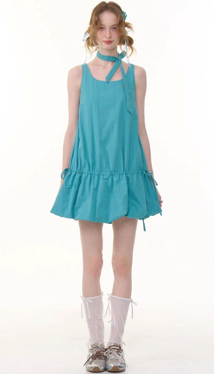 Woman in a blue dress with a matching choker and white socks on a white background