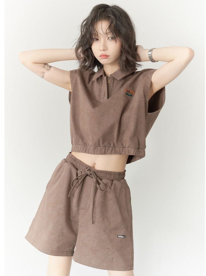 Woman in a brown crop top and shorts with hands behind her head