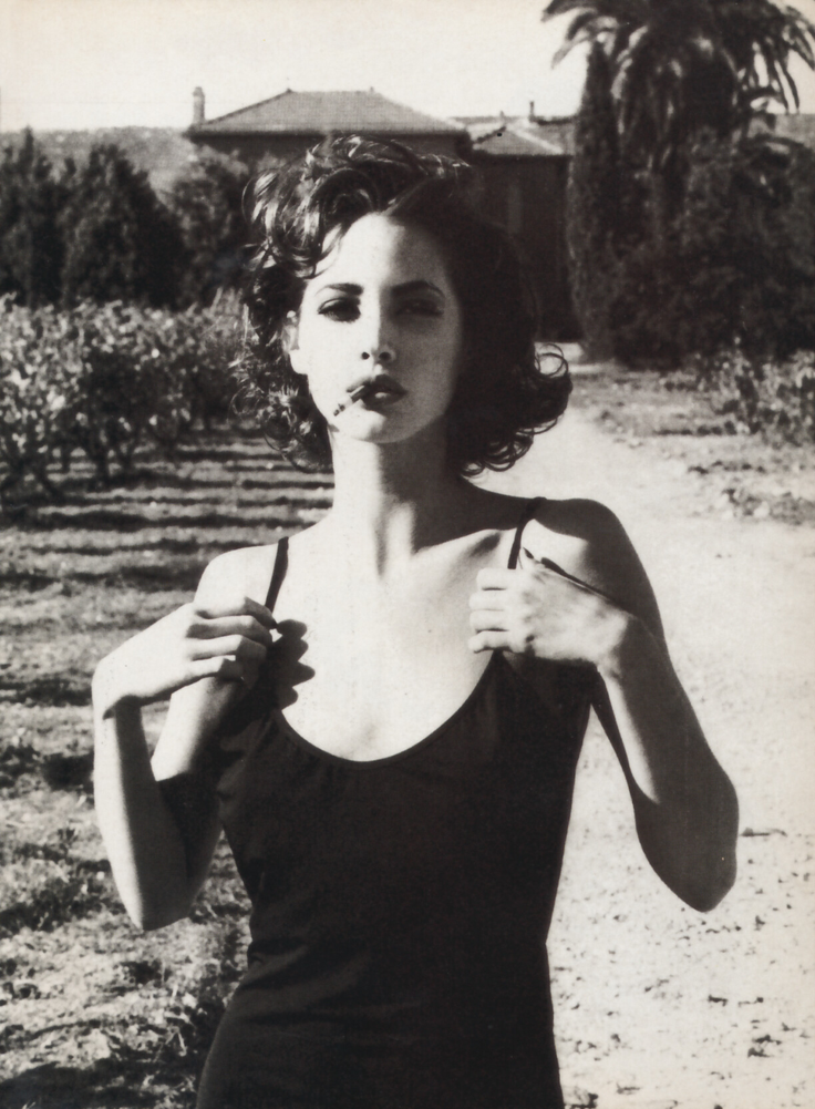 Woman with short curly hair in a black top in a vineyard