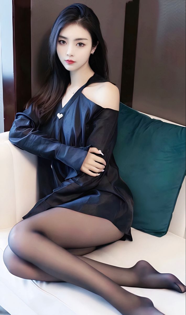 Woman with long black hair wearing an off-shoulder top and black pantyhose