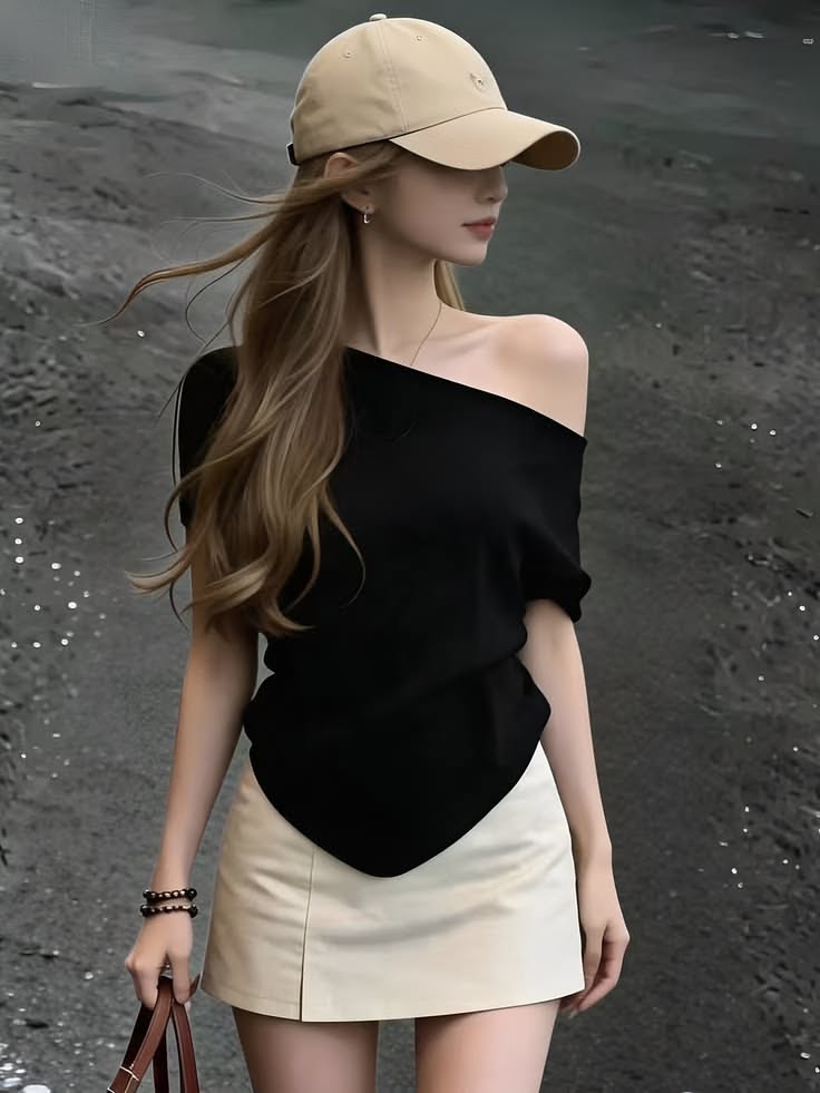 Woman in a black off-shoulder top and mini skirt with a baseball cap