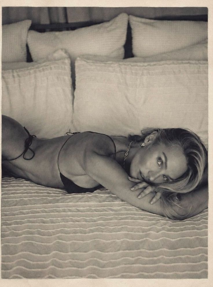 Woman in a bikini lying on a bed in a suggestive pose