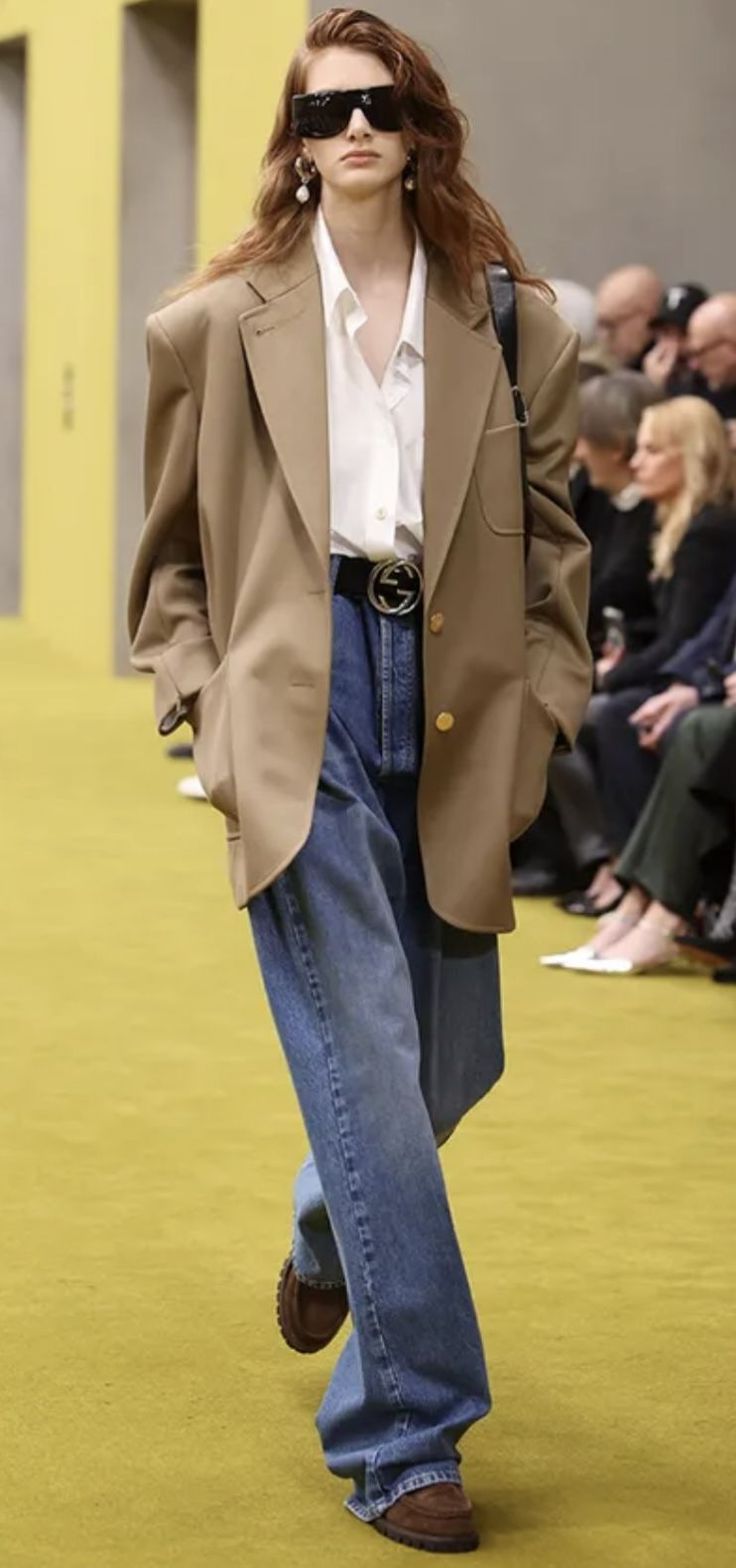 Runway model in an oversized blazer, wide leg jeans, and sunglasses