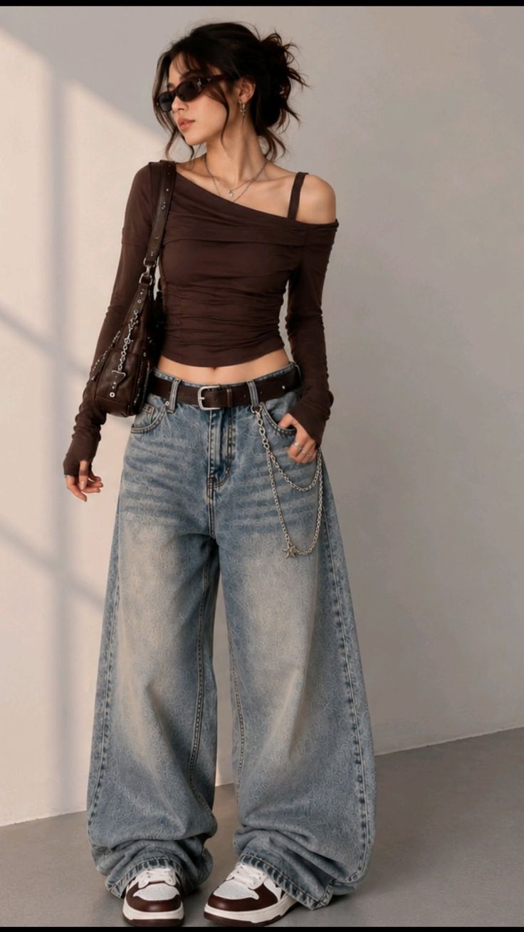 Woman in an off-shoulder top and baggy jeans with a chain accessory