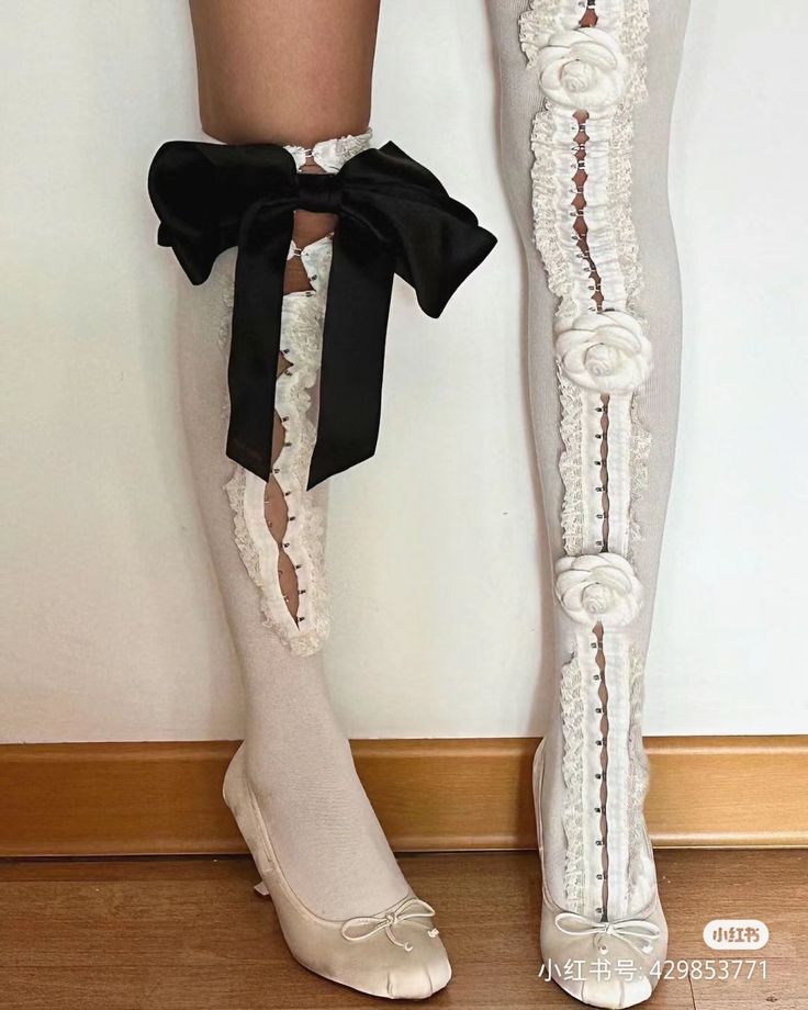 Legs wearing white stockings with lace, bows, and ballet flats