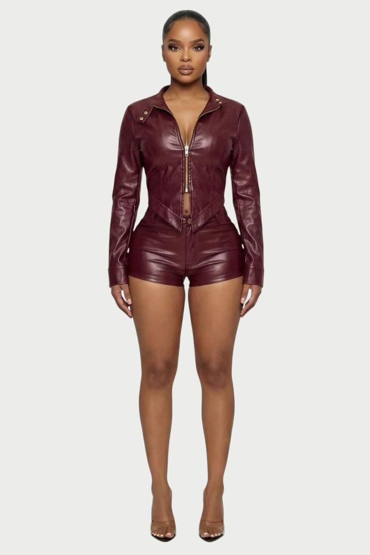 Woman in a burgundy leather jacket and shorts with high heels