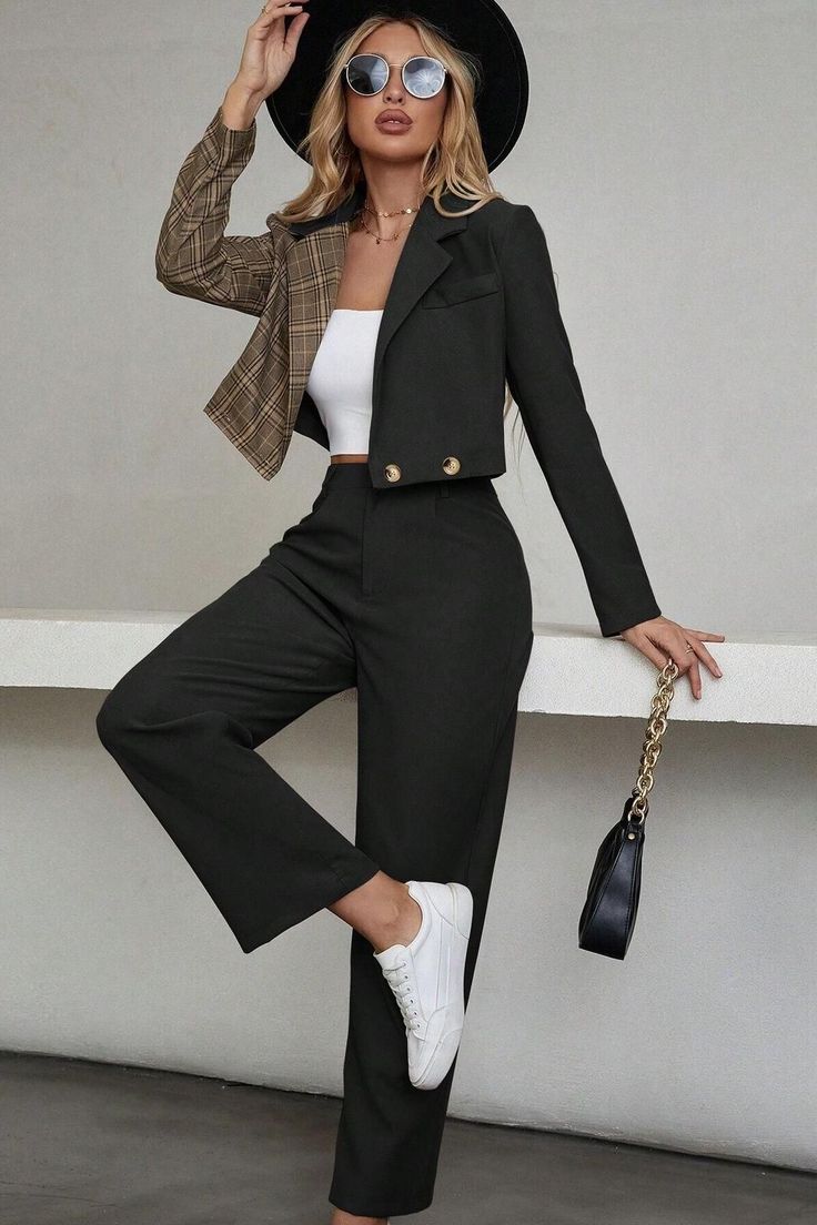 Woman in a cropped blazer with plaid sleeve, wide leg pants, and a black hat