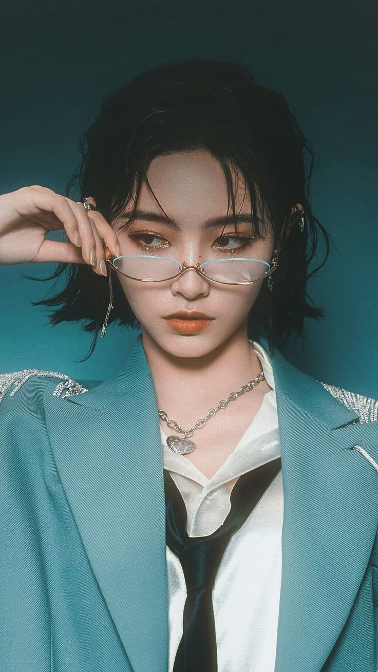 Person in a blue blazer and glasses looking directly at the viewer