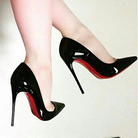 Woman's legs wearing black high heels with red soles