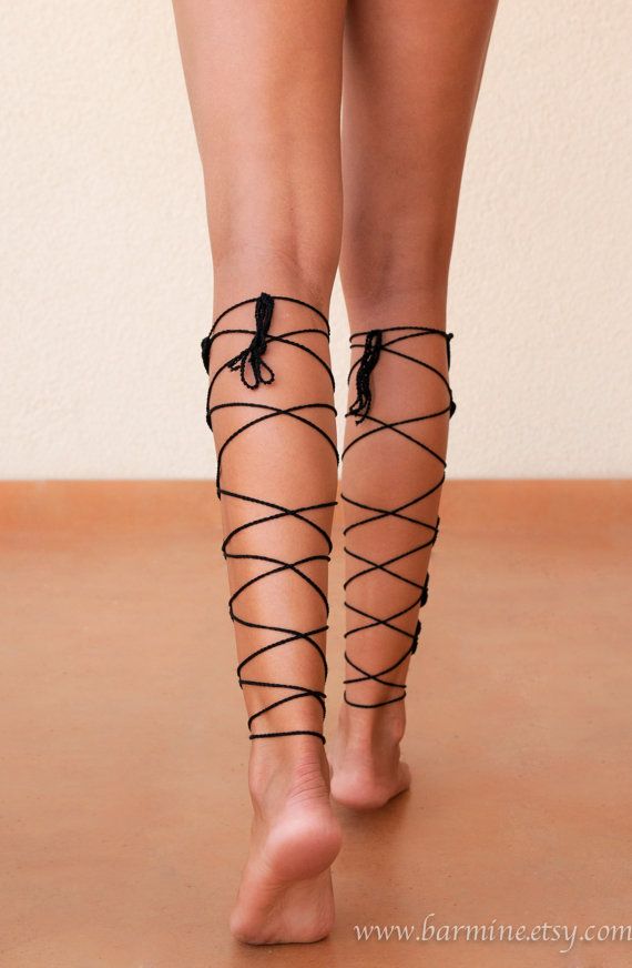 Bare legs with black laces wrapped around them, walking away from the camera