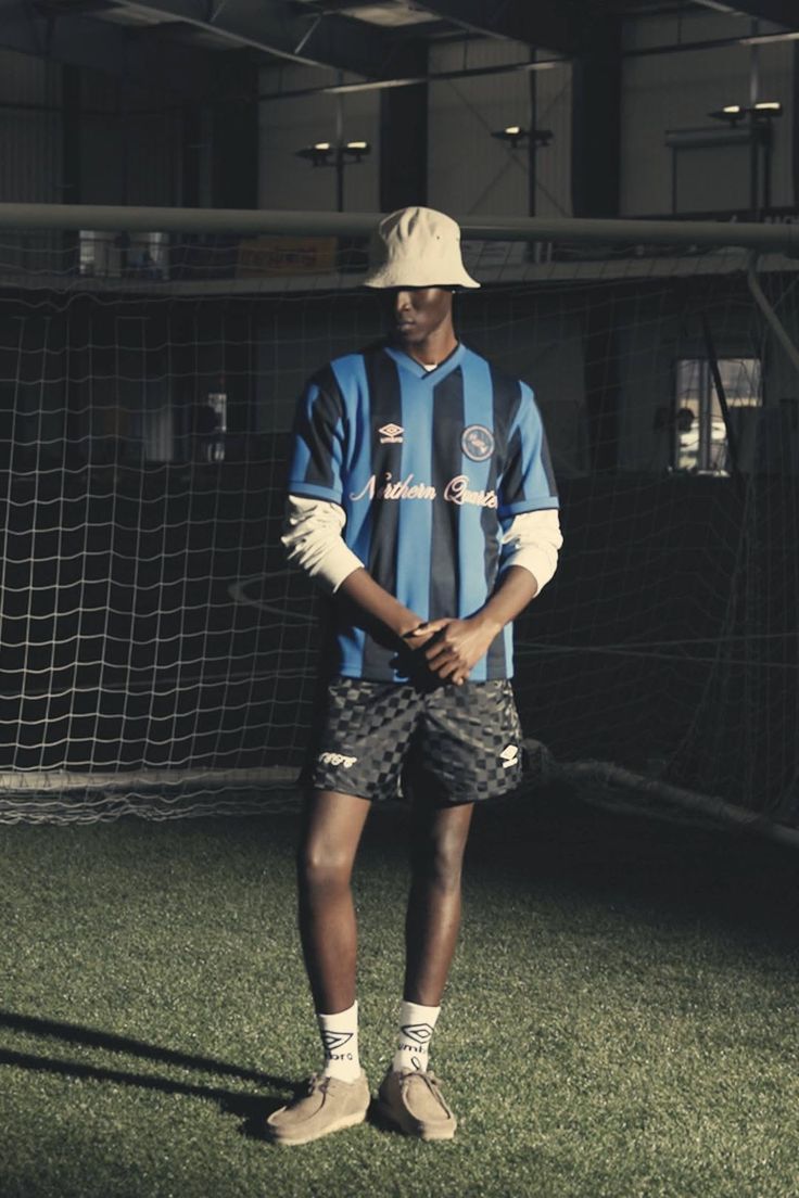 Person in a soccer jersey and bucket hat on an indoor soccer field