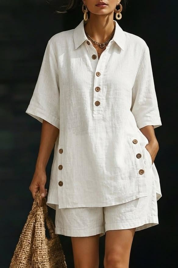 Woman in a white linen shirt and shorts holding a straw bag