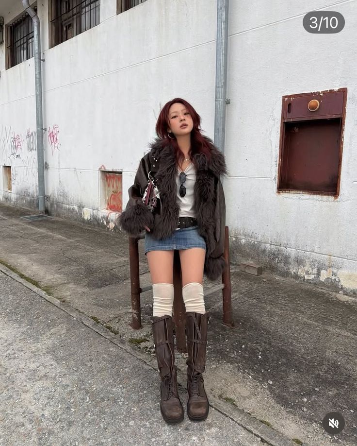 Woman in a fur coat, denim skirt, and knee-high boots on a street