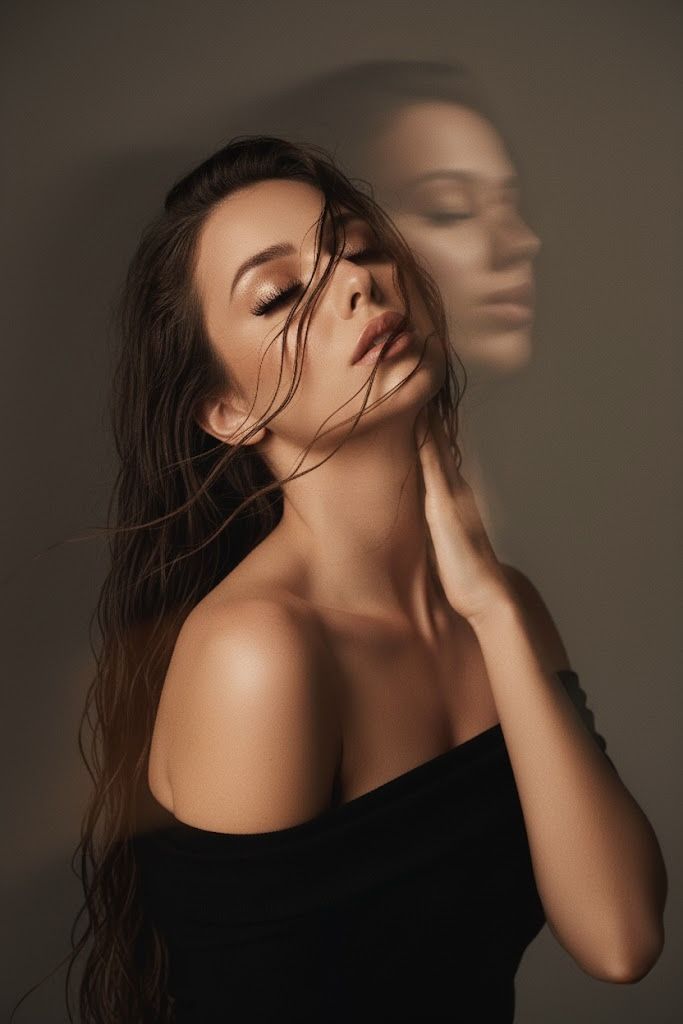 Woman with wet hair and an off-shoulder top, eyes closed, with a blurred reflection