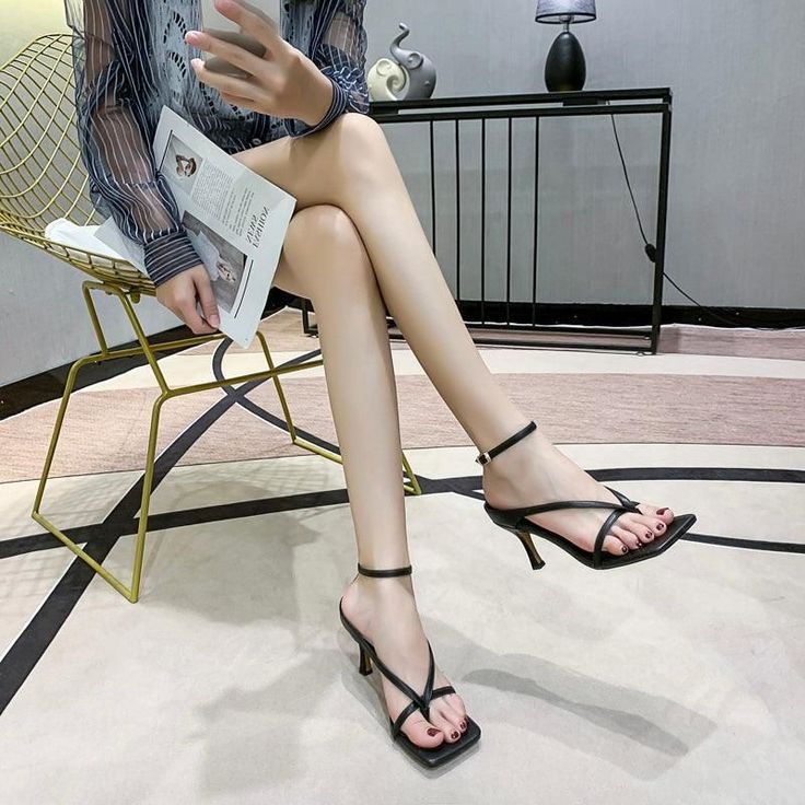 Person in a striped shirt and black high heels sitting indoors