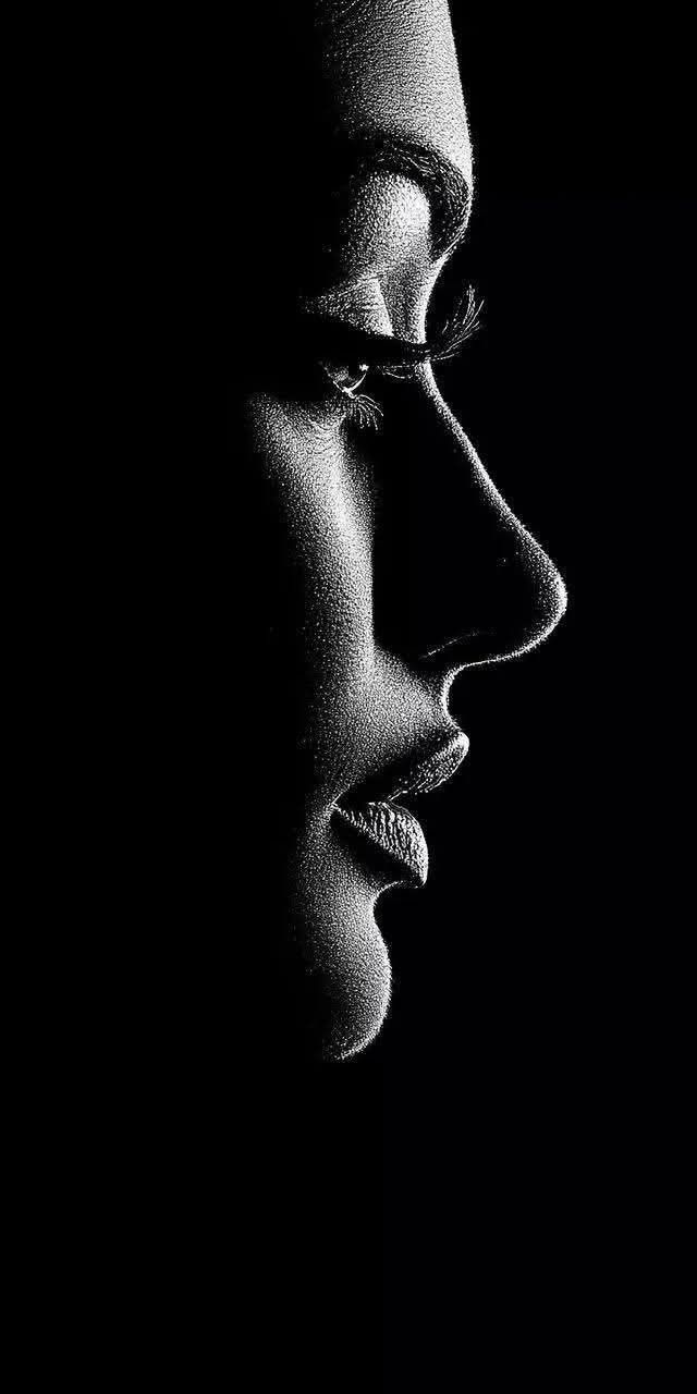 Black and white profile of a face with dramatic lighting and high contrast
