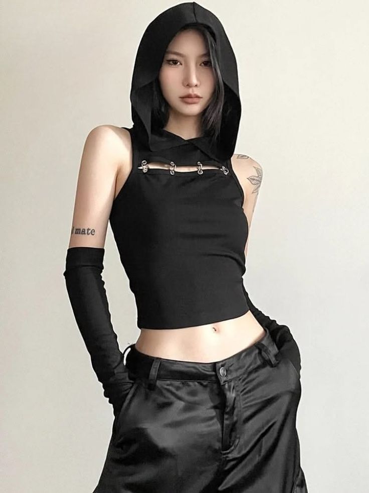 Woman in a black hooded crop top and long gloves with exposed midriff