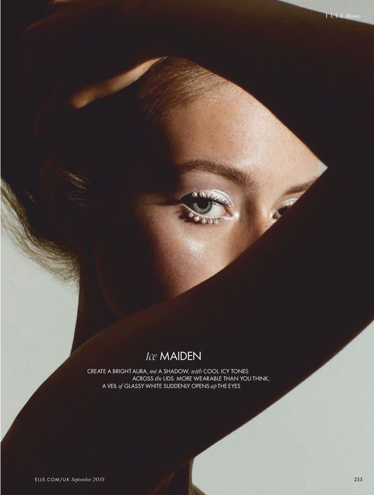 Close up of a woman's eye with white eyeliner and pearls, dramatic lighting