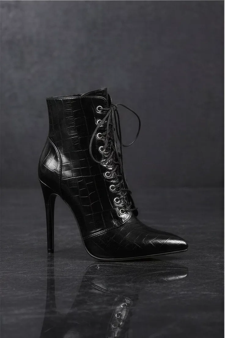 Black high-heeled lace-up ankle boot with crocodile texture on a dark background