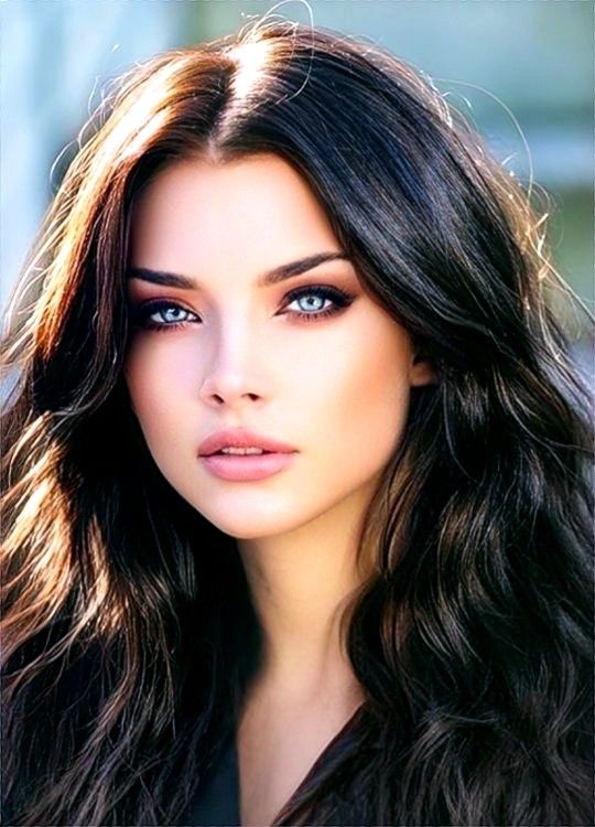 Woman with long dark hair and blue eyes in a close-up portrait