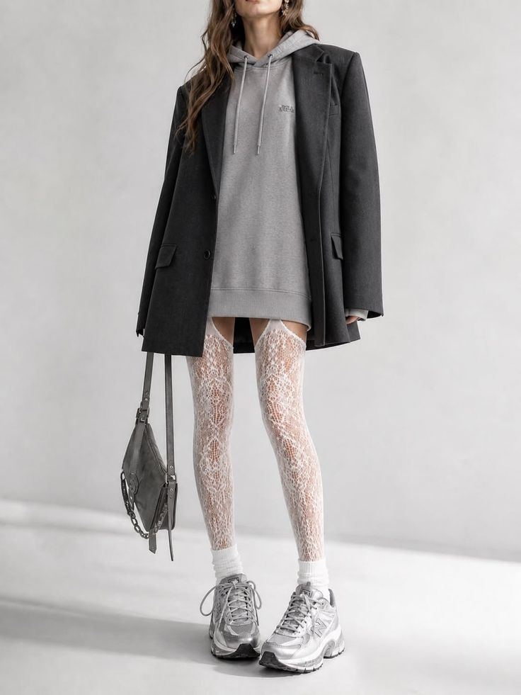 Woman in an oversized blazer, hoodie dress, and lace stockings