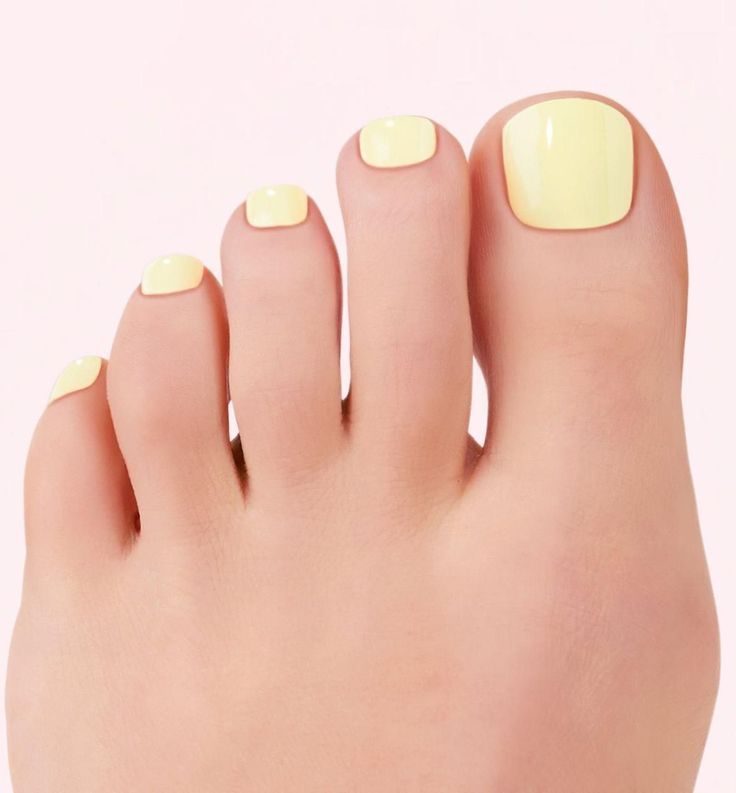 Close up of toes with bright yellow nail polish