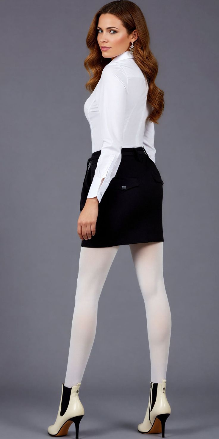 Woman in a white shirt, black skirt, and white tights posing in a studio