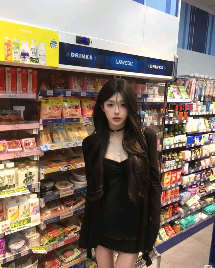 Woman with long black hair in a black dress inside a convenience store
