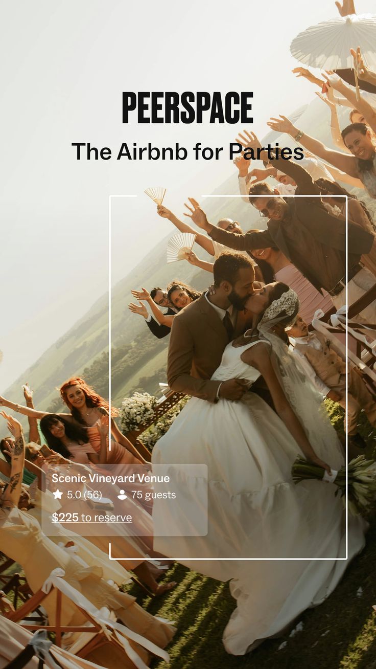 Bride and groom kissing at an outdoor wedding with guests cheering