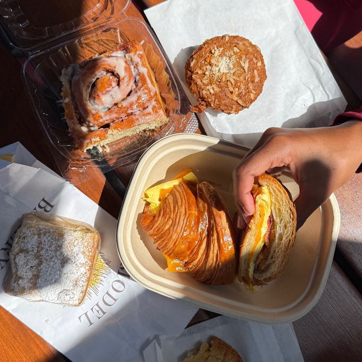 Assortment of bakery items including a cinnamon roll, muffin, and croissant sandwich