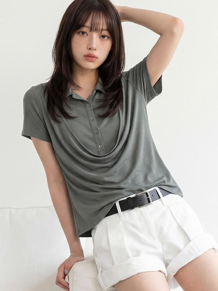 Woman with long hair and freckles wearing a polo shirt and white shorts