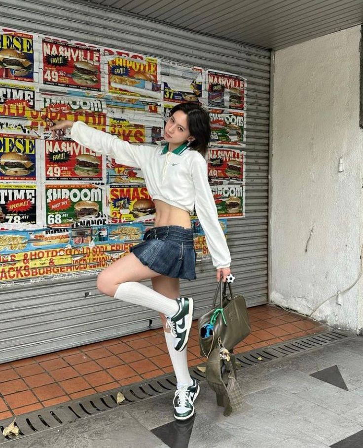 Woman in a denim skirt and crop top posing outdoors
