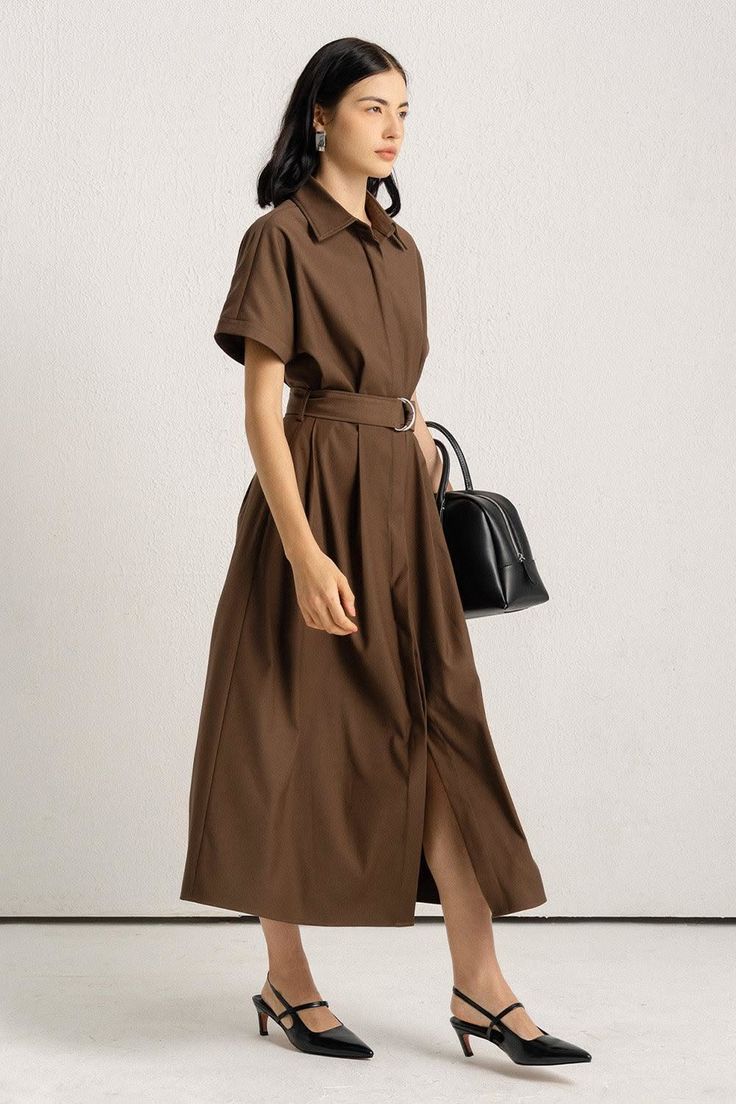 Woman in a brown shirt dress with a black handbag and heeled shoes