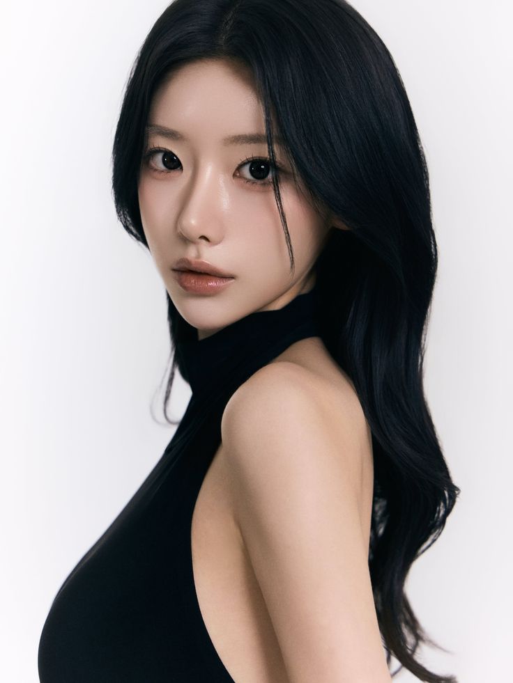 Woman with long black hair wearing a black halter top against a white background