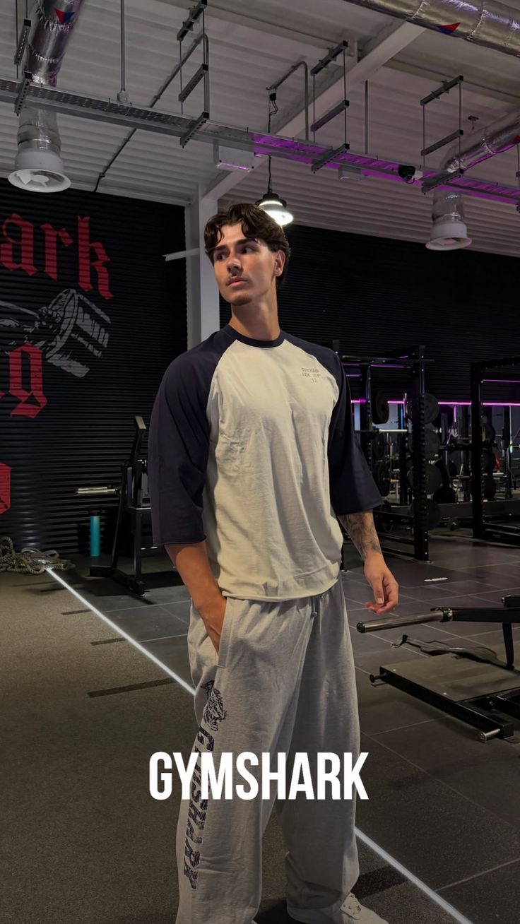 Man in a gym wearing athletic wear, looking to the side