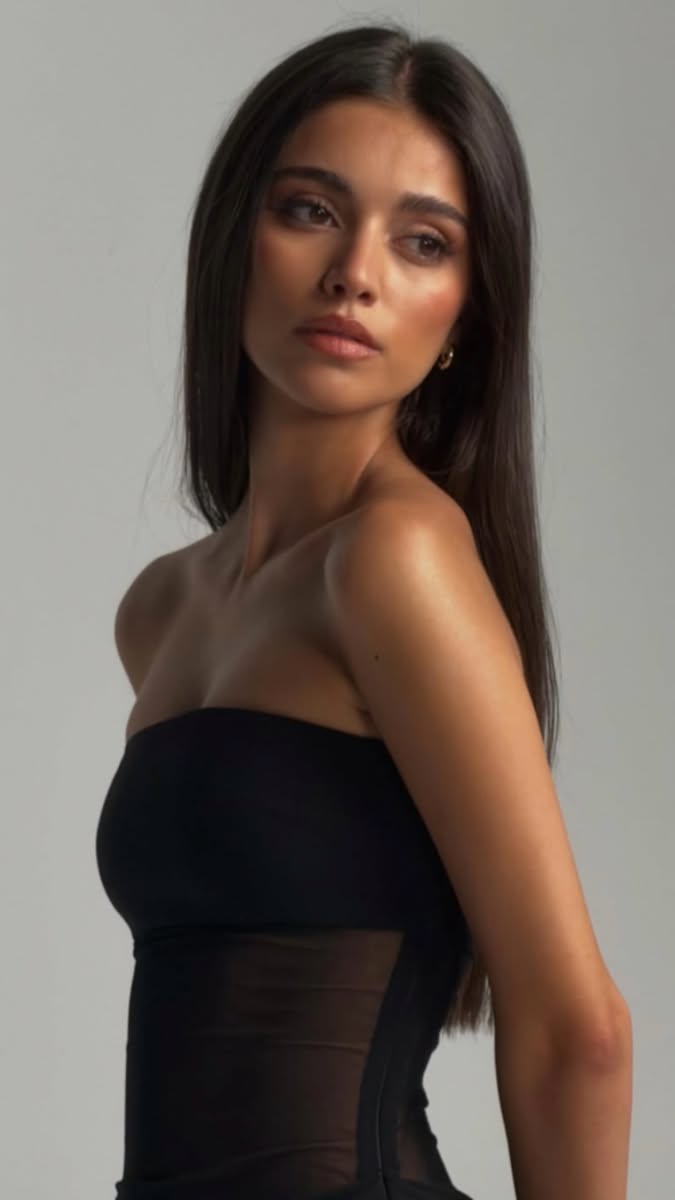 Woman with long dark hair wearing a strapless top with sheer fabric