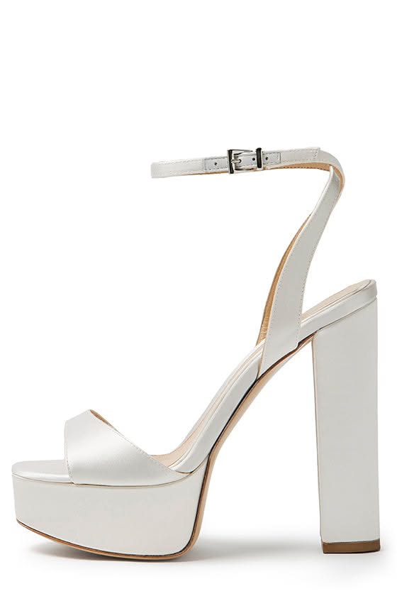 White satin platform heels with an ankle strap and chunky heel
